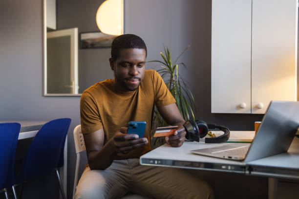 istock Young African American man using online payment services at home 2148328382