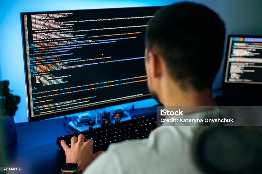 Smart Male Programmer Sits At Home Office In Front Of Computer Screen ...