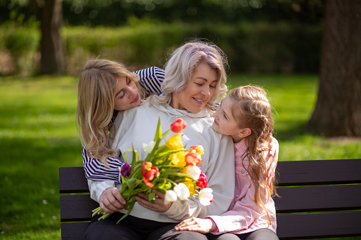 Three generations family with tulip bouquet.