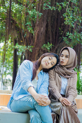 friendship Asian women smiling kissing long time no see looking at camera in campus park. student for the concept of human interest and lifestyle