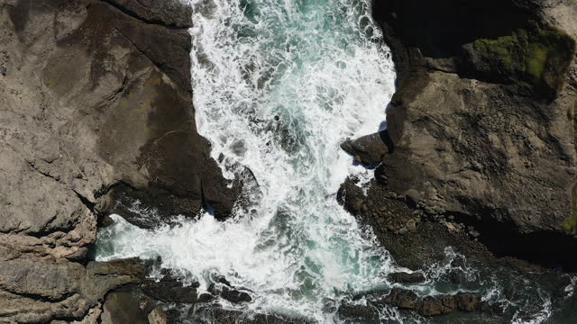 Ascending above a pool of white water smashing onto a rocky shoreline. New Zealand.