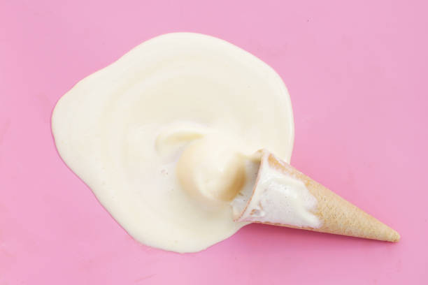 Melting ice cream balls with waffle cone on pink background.