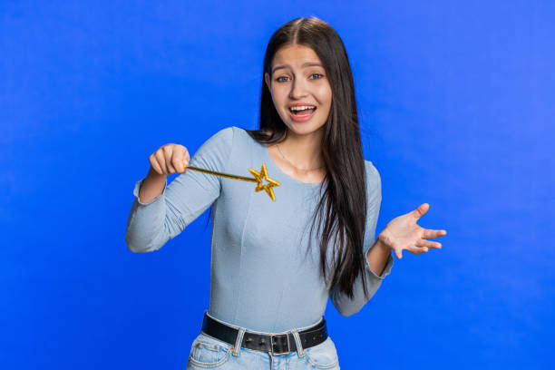 istock Magician witch young woman gesturing with magic wand making wish come true, casting magician spell 2148332228
