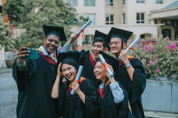 istock Asian university students in graduation gown taking selfie with smartphone with classmate 2148332673