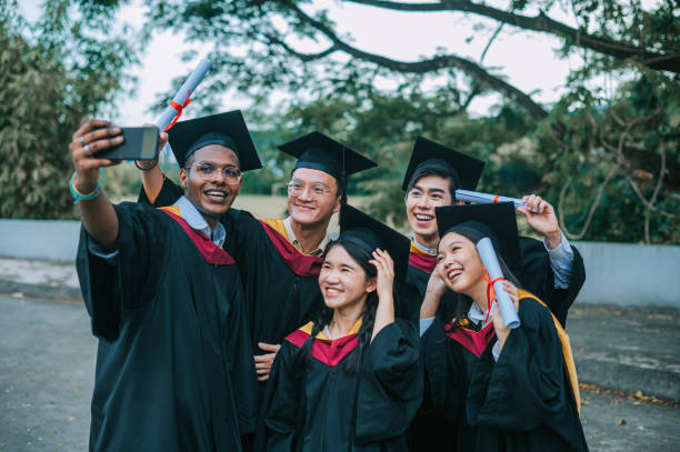 istock Asian university students in graduation gown taking selfie with smartphone with classmate 2148332682