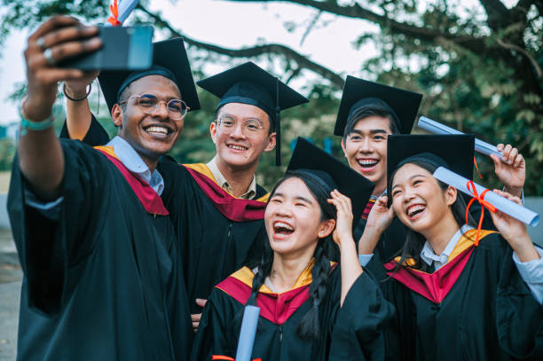 istock Asian university students in graduation gown taking selfie with smartphone with classmate 2148332684
