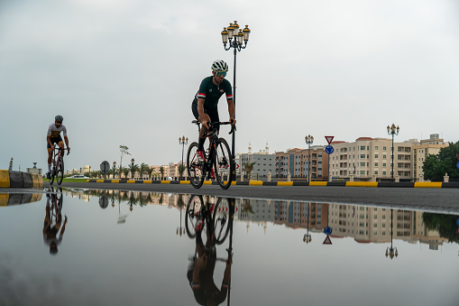 a cyclist Riding a bike down the street at a competition in Sharjah. uae. January 28, 2024.