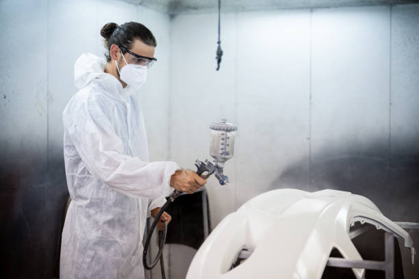 istock Automotive service worker in protective gear painting bodywork. Oxus 2148334235