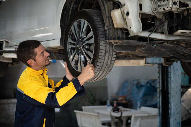 istock Hardworking mechanic changing car wheel in auto repair workshop. Oxus 2148334554