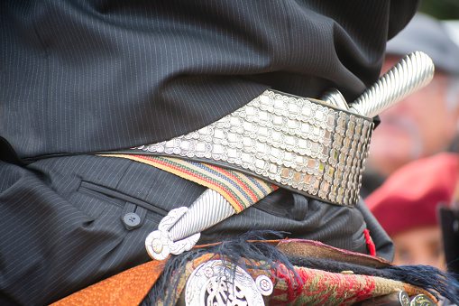 the intricate craftsmanship of a gaucho's ornate belt and facon, meticulously fashioned from gleaming gold and silver.