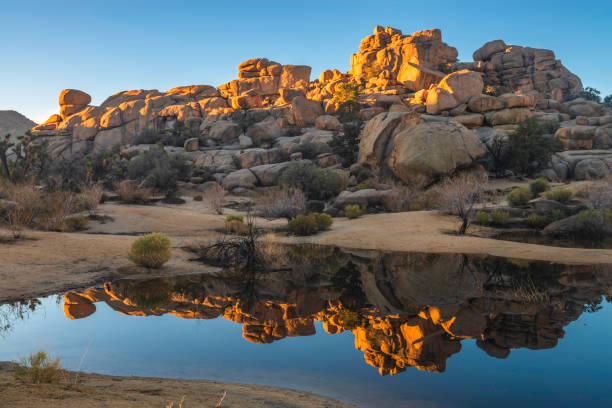 istock Sunrise on Sandstone Boulders Reflected in the Lake at Barker Dam 2148336880