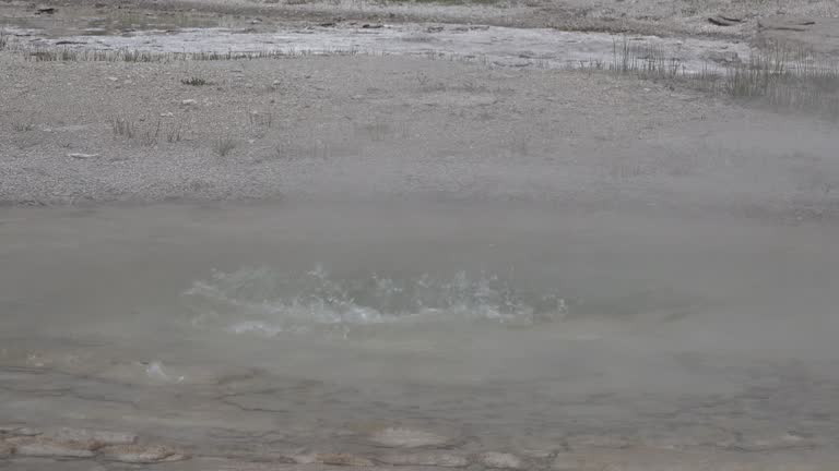 Hot water boils in the mouth of the operating geyser. Yellowstone National park, Wyoming, USA