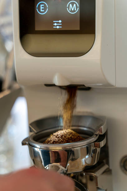 Coffee beans in a portafilter by the coffee grinder