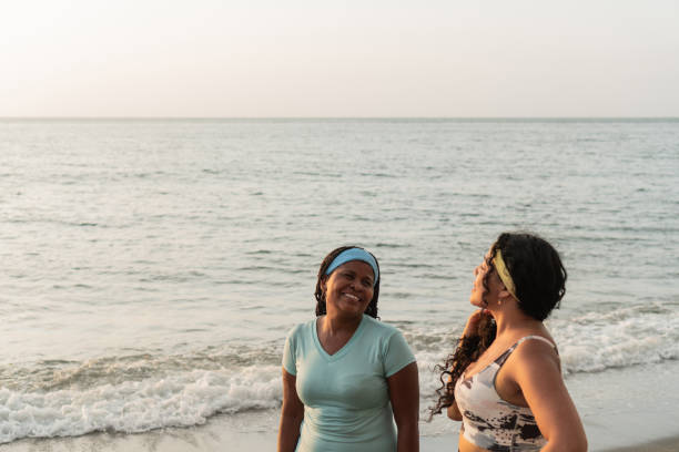istock Smiling Women Sharing a Laugh on a Calm Beach at Dusk 2148338661