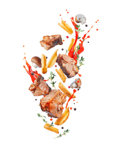 istock Fried beef steaks with baked potatoes in the air isolated on a white background 2148338694