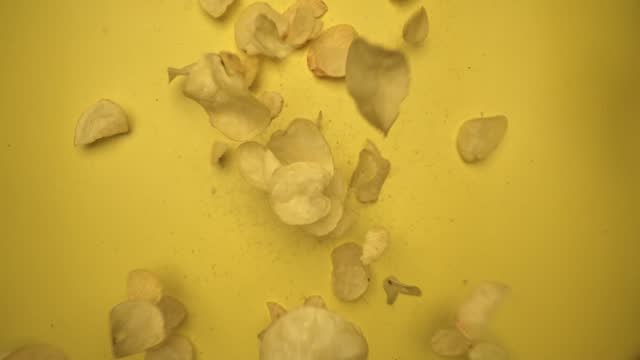 Slow motion of flying snack in air to camera with yellow background. Comestible.