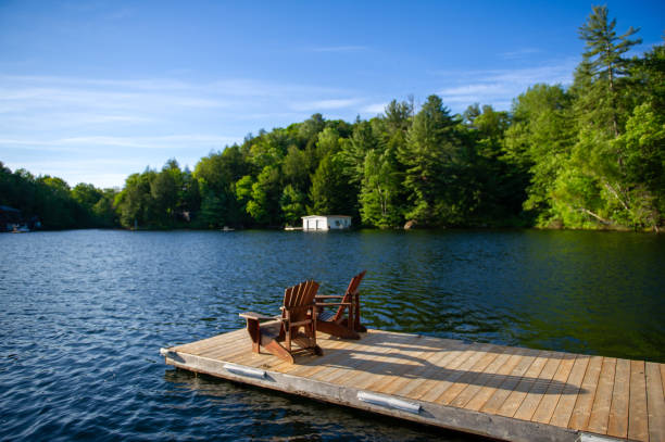 istock Two Adirondack chairs on a wooden dock on a summer morning 2148342889