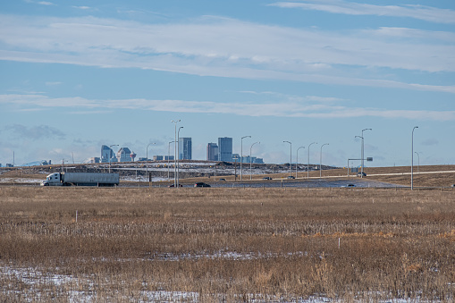 Traffic on Stoney trail with Calgary skyline and mountains