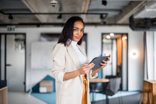 istock Confident Hispanic Businesswoman Analyzing Data on Tablet. 2148345380
