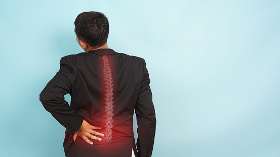 Man with backache. Pain in the human body. Muscular male body. Isolated on white background. Black and white photo with red dot