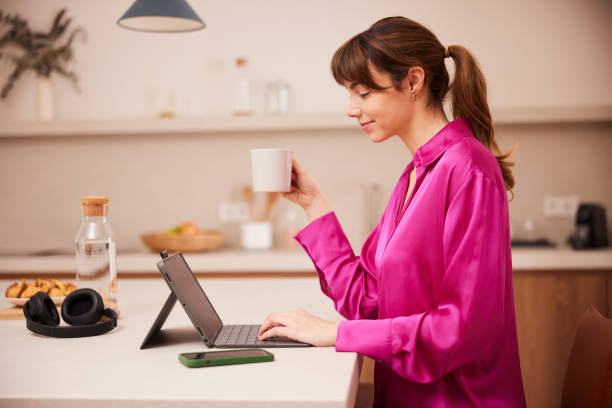 istock Coffee Break: Businesswoman Sips Coffee and Surfs Web on Tablet 2148351844
