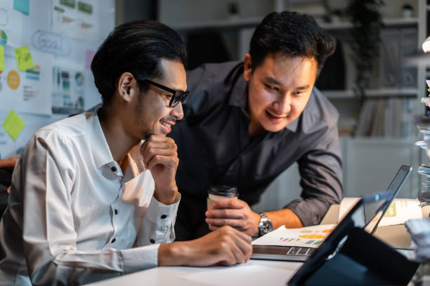 istock Asian handsome two businessman using laptop computer working in office. Attractive male employee brainstorm and meeting as team, plan and discuss project in workplace. Corporate of modern colleagues 2148353251