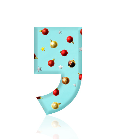 Close-up of three-dimensional Christmas ornament Comma symbol on white background.