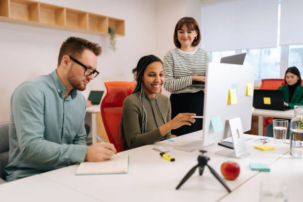 istock Positive multiethnic colleagues employees cooperating in office talking working together at workplace. Diverse young startup business team coworkers discussing 2148354353
