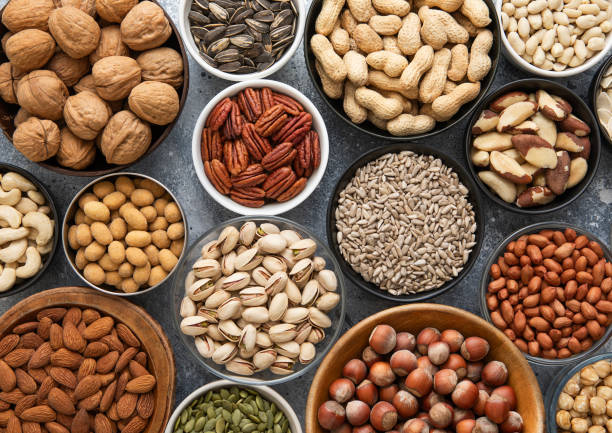 istock Mixed healthy nuts and seeds in various bowls on kitchen table.Peanut,hazelnut,walnut,almonds,pistachio,sunflower,pumpkin,chia and cashew.Top view. 2148355246