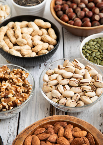 istock Mixed raw nuts and seeds in bowls on kitchen table.Peanut,hazelnut,walnut,almonds,pistachio,sunflower,pumpkin,chia and cashew.Macro 2148355287