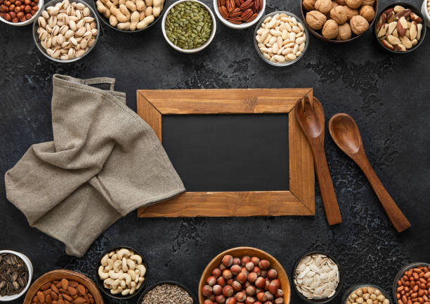 istock Peanut,hazelnut,walnut,almonds,pistachio,sunflower,pumpkin,chia,pecan and cashew mixed healthy nuts and seeds with menu board and kitchen utensils.Top view. 2148355313