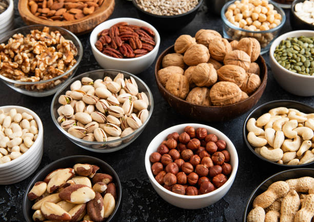 istock Mixed raw nuts and seeds in bowls on kitchen table.Peanut,hazelnut,walnut,almonds,pistachio,sunflower,pumpkin,chia and cashew.Macro 2148355341