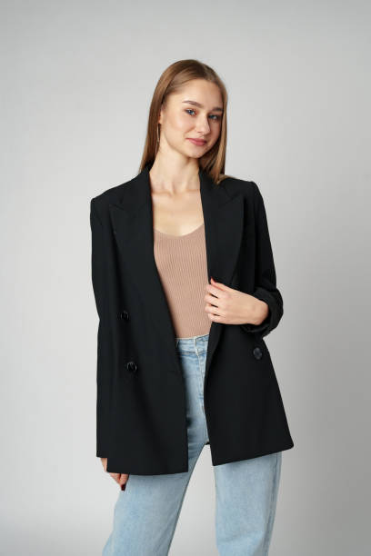 istock Young Woman Wearing Black Jacket and Jeans posing on gray background studio shot . 2148355663