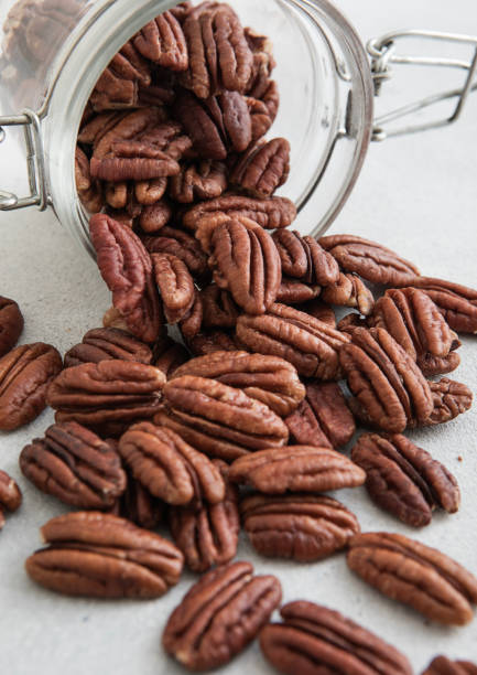 istock Raw healthy pecan nuts snack in glass jar on white kitchen table.Macro. 2148355677