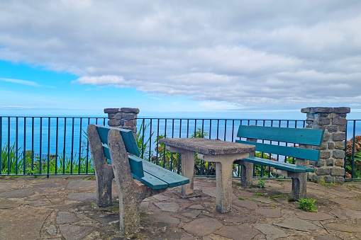 A bench and a table with a beautiful view of the ocean