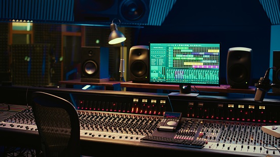 Music recording studio control room with daw software used to mix and master audio tracks, empty soundproof professional space. Modern sliders on control panel board to edit sound waves.