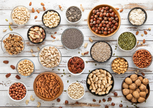 istock Mixed assorted raw healthy nuts and seeds in various bowls on light wooden table.Peanut,hazelnut,walnut,almonds,pistachio,sunflower,pumpkin,chia and cashew.Top view. 2148355966