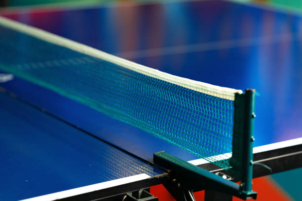 Tennis net on a blue table tennis court. Close-up. Table tennis net on a blue background. Selective focus.