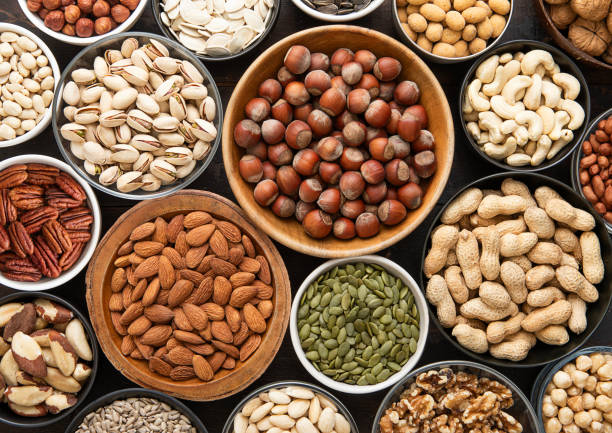 istock Mixed healthy nuts and seeds in various bowls on dark kitchen table.Peanut,hazelnut,walnut,almonds,pistachio,sunflower,pumpkin,chia and cashew.Top view. 2148356460