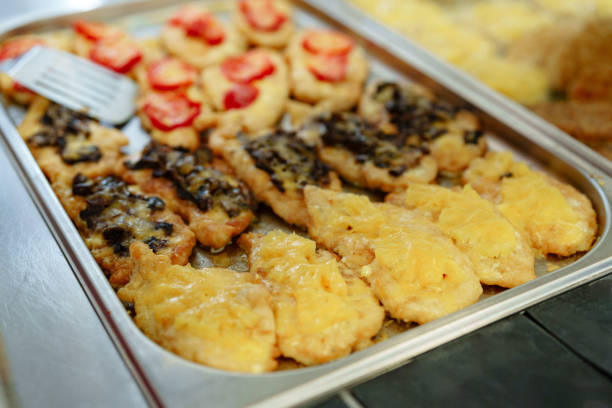 A buffet table filled with a diverse selection of dishes, including salads, meats, fruits, and desserts. The spread is visually appealing and offers a wide range of choices for guests to enjoy at an event or gathering.