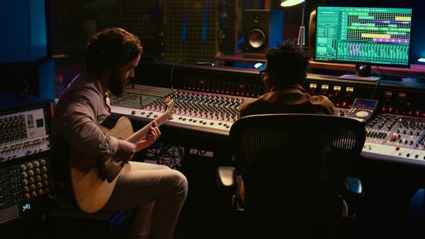 istock Guitarist recording his electro acoustic guitar tunes on audio editing software 2148356472