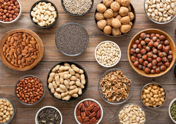 istock Peanut,hazelnut,walnut,almonds,pistachio,sunflower,pumpkin,chia,pecan and cashew mixed healthy nuts and seeds in various bowls on wooden background.Top view. 2148356474