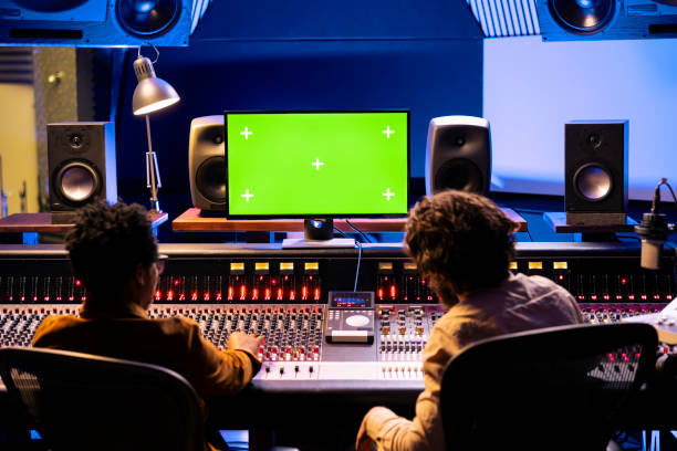istock Team of audio experts mixing and mastering music next to mockup 2148357289