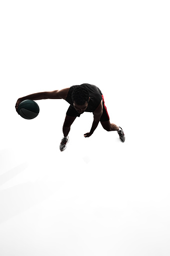 Top view image, silhouette of man, basketball player in motion during game, training, playing isolated on white background. Concept of professional sport, competition, game, tournament, action