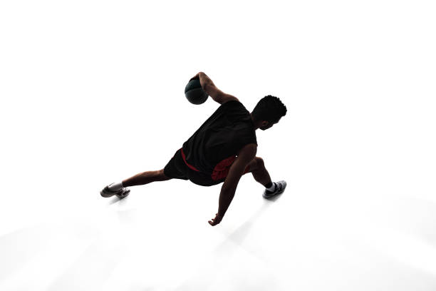 Top view image, silhouette of man, basketball player in motion during game, training, playing isolated on white background. Concept of professional sport, competition, game, tournament, action
