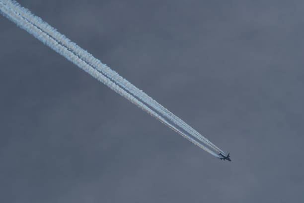 istock airplane in the cloudy sky with contrail 2148358821