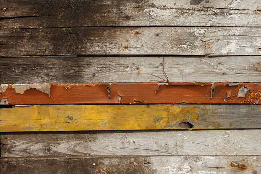 Wooden background of old boards, some of them painted. Old grunge wooden wall