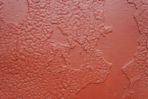 Old cracked surface is painted with brown oil paint. Close-up. Texture. Abstract background