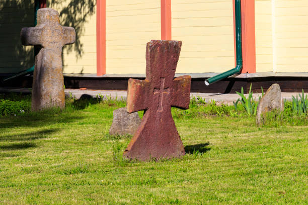 Leaning metal cross on a grave yard.