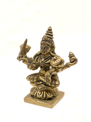 vintage metal figure of hindu goddess mahalakshmi in detail sitting cross legged isolated in a white background